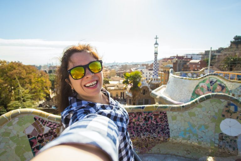 Young woman making selfie in Park Guell, Barcelona, Spain.